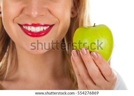 Close up picture of a beautiful woman's red lips and a fresh green apple