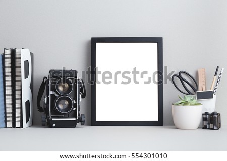 Mock with black frame and medium format camera, roll of films, books, office supplies. Photographer workspace.