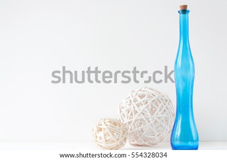 Minimal elegant composition with rattan balls and blue bottle