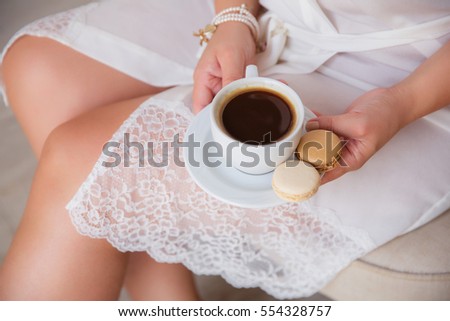 Beauty girl with cup of coffee and macaroon, bride's morning, cozy morning. Selective focus