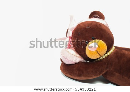Plush toy bear lying on its side with a pink heart on isolated white background. Valentine day