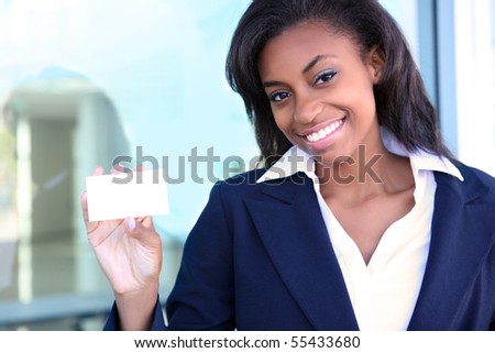 African American woman holding business card at office building