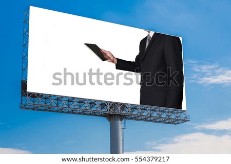 Businessman looking the tablet display on billboard with white space - can advertisement for display or montage product and business