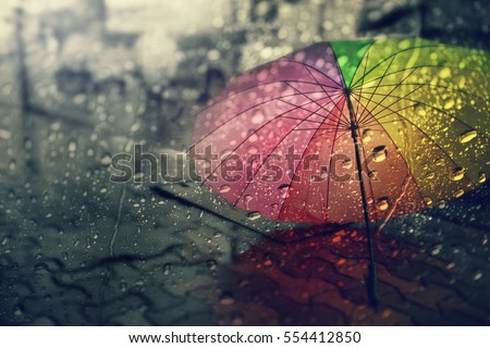 Blurry of umbrella ,view through the window on rainy day.  Royalty-Free Stock Photo #554412850