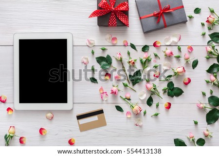 Valentine day internet sales concept, online shopping holiday background. Tablet screen with copy space on white wood with rose flowers heart and credit card, top view. Advertising mockup