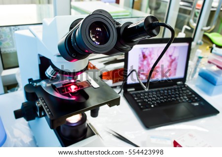 Microscope that was connected with camera at eyepiece into computer, background of laboratory (selective focus)