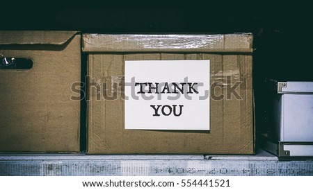 paper box with paperwork, the inscription on a white sheet of paper thank you