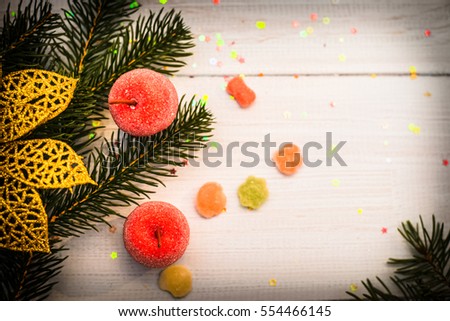 Gold flower puansemtiya, fir branch, miniature red apples and candy on a blue table, bokeh, vignetting,  picture