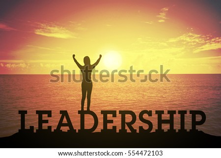 Silhouette young woman standing and raising up hand about winner concept at LEADERSHIP text over a beautiful sunset or sunrise at the sea. background for success in 2017 years .hope business success