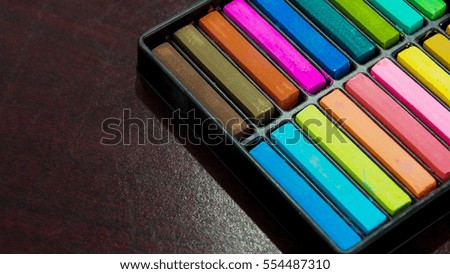 Colorful chalk pastel on the dark wooden table