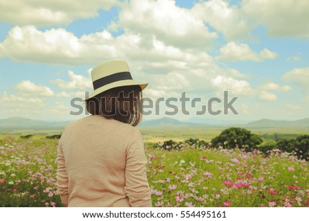 Woman stand alone with cosmos field surround  with sky background