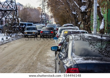 Cars in the city, Parking at the roadside. The narrow street. Winter day.