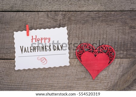 Valentine's card. Red heart with sheet with text on wooden old board.