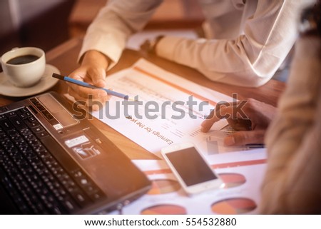 Boss is clarifying about the margin target and year plan for his assistant on wooden working table.selected focus at a part of paper graph. Royalty-Free Stock Photo #554532880