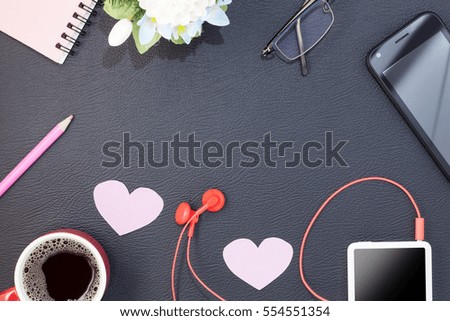 red coffee cup with music player and red earphone on black leather background