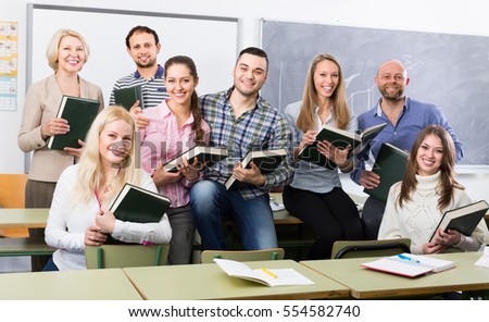 Group of happy cheerful students and coach posing at training session school. Selective focus Royalty-Free Stock Photo #554582740