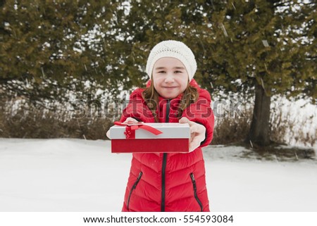 Girl gives a gift of Christmas. Picture of a falling snow