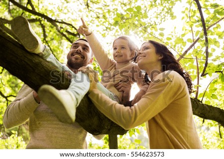 family, parenthood, adoption and people concept - happy mother, father and little girl in summer park having fun Royalty-Free Stock Photo #554623573