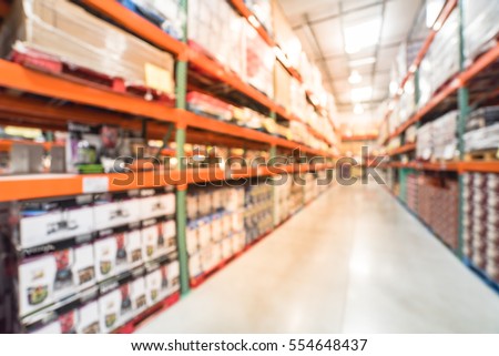 Blurred image large warehouse with row of aisles and shelves from floor to ceiling with bin number. Defocused background of industrial distribution interior aisle, inventory, hypermarket, wholesale. Royalty-Free Stock Photo #554648437