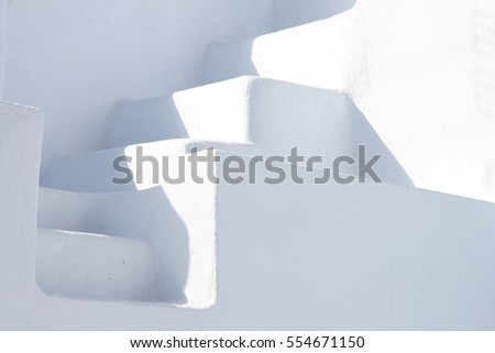 Minimal white stone staircase between two white walls, Oia, Santorini, Greece.
