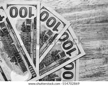 Wallpaper for money and financial success. A lot of banknotes of american dollars  background black and white surface
