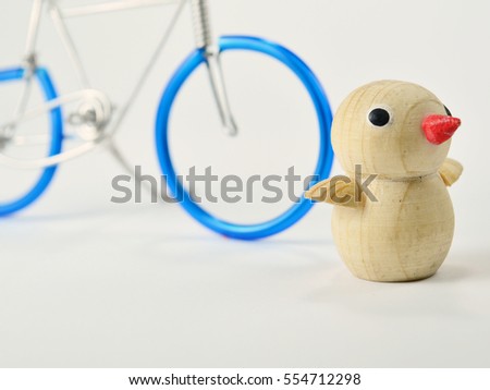 Wood penguins 
and a bicycle made from wire on a white background
