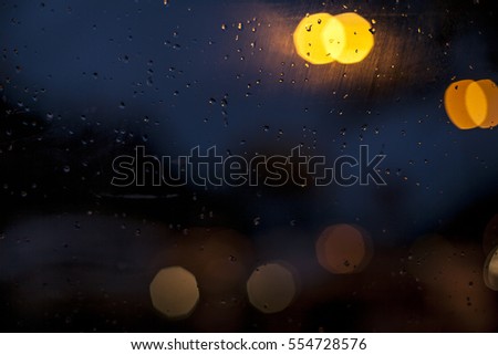 the rain outside the window. rain drops on glass, powerpoint background, night, blue and yellow. 