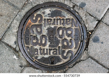 Old dirty iron cover of a manhole for access to natural gas pipeline