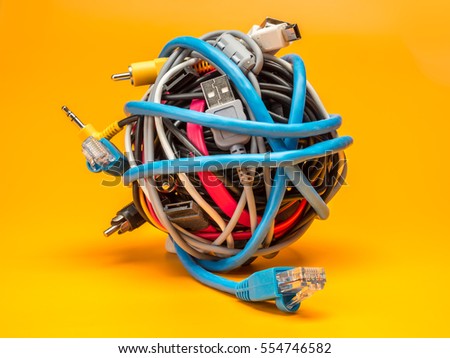 Tangled roll of computer wires over yellow background Royalty-Free Stock Photo #554746582