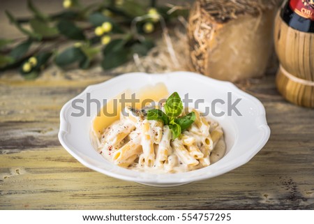 Pasta with sauce in the white plate. Italian pasta close-up on a wooden table. Royalty-Free Stock Photo #554757295