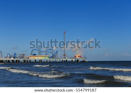 Pleasure Pier from the water/ Galveston Island Pleasure Pier/ The Pleasure Pier rides reaching out over the water on Galveston, Texas, USA. Royalty-Free Stock Photo #554799187