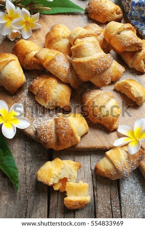 crescent rolls with apricot jam on rustic wooden background. selective focus