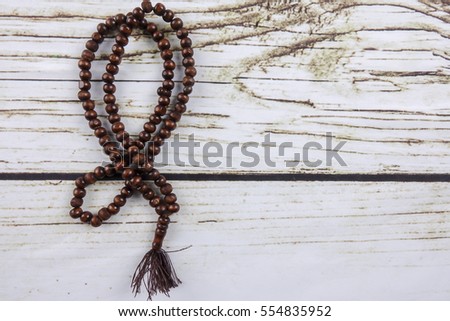 the wooden tasbih or rosary on wooden background.