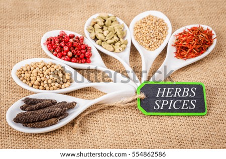 various spices and herbs with herbs spices label on sack background.