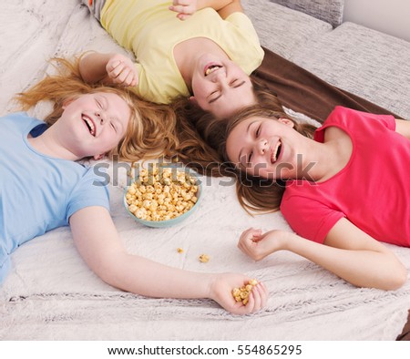 happy little girls  eating popcorn at home