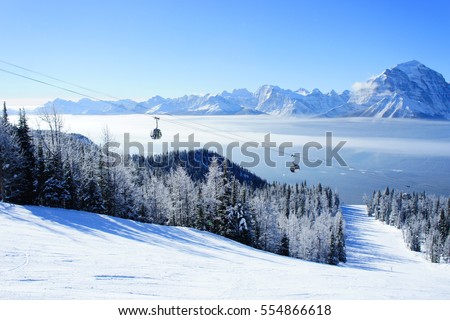 Picture of temperature inversion at Lake Louise, causing a cloud of sea with gondola visible. Royalty-Free Stock Photo #554866618