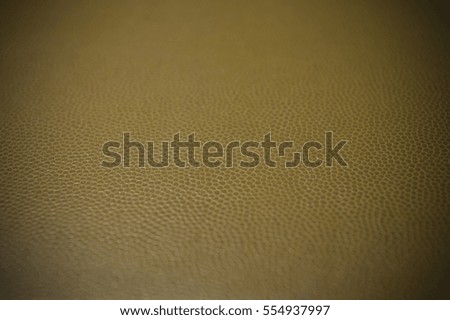 Vignetted artificial dark beige leather texture close up