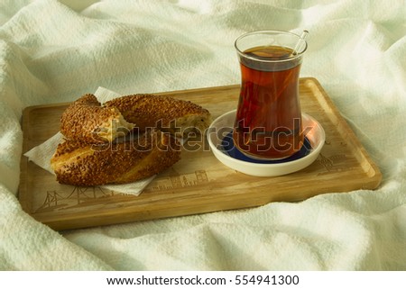 Bagel and cup of turkish tea on the wood tray with Istanbul picture on the bedcover, breakfast in bed