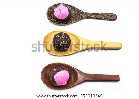 sweet chocolate and handmade cake ball in the wooden ladles isolated on white background.