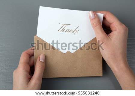 Women's hands with a letter in his hand with the words thank you Royalty-Free Stock Photo #555031240