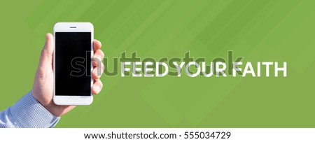 Smart phone in hand front of green background and written FEED YOUR FAITH