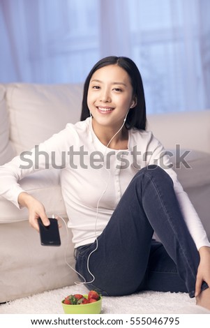 	young woman leans against sofa making a call and eating st
strawberries	