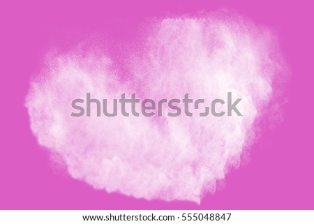 Heart shaped powder splatted on colored background.Colored powder explosion on  background.