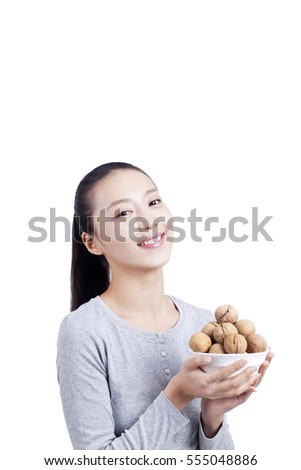	young woman holds a bowl of walnuts	