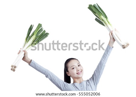 	young woman holds a bunch of spring onions	