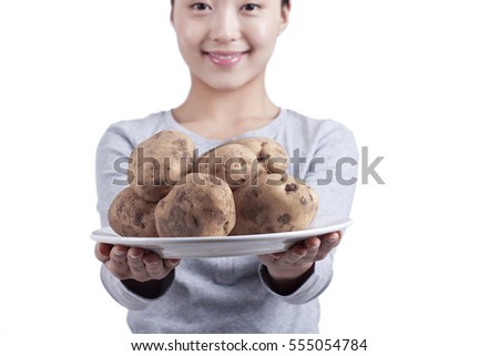 	young woman holds a plate of potatoes	