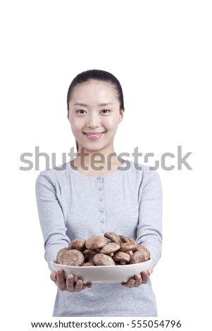 	young woman holds a plate of mushrooms	