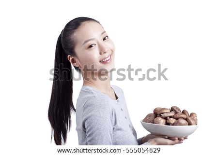 	young woman holds a plate of mushrooms	