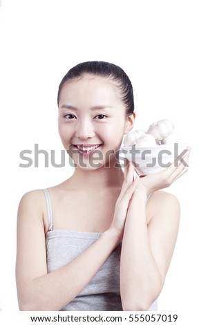 	young woman holds a bowl of garlics	