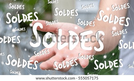 Businessman on blurred background holding sales icons in his hand 3D rendering ("soldes" means "sales" in french)